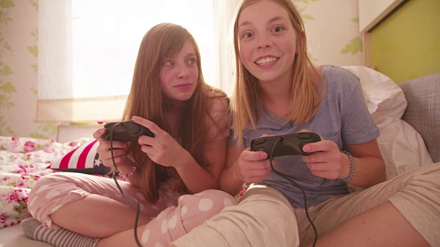 女孩们一起在卧室里玩电脑游戏视频下载