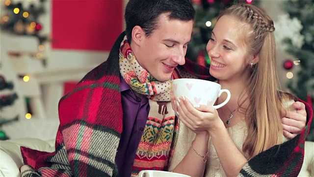 一对恩爱的情侣在圣诞节手捧杯子和饮料视频素材