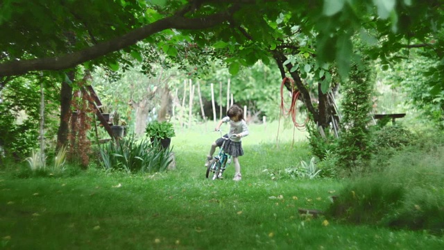 可爱的女孩在大自然中骑自行车视频下载
