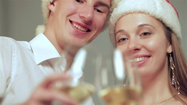 一对美丽的情侣在圣诞节拿着香槟对着镜头视频素材