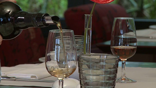 餐馆里，女服务员将杯子装满了马德拉红葡萄酒视频素材