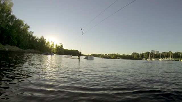 一个人在湖上用慢动作在尾流板上做极限特技视频素材