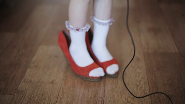 滑稽的小女孩穿着妈妈的鞋视频素材