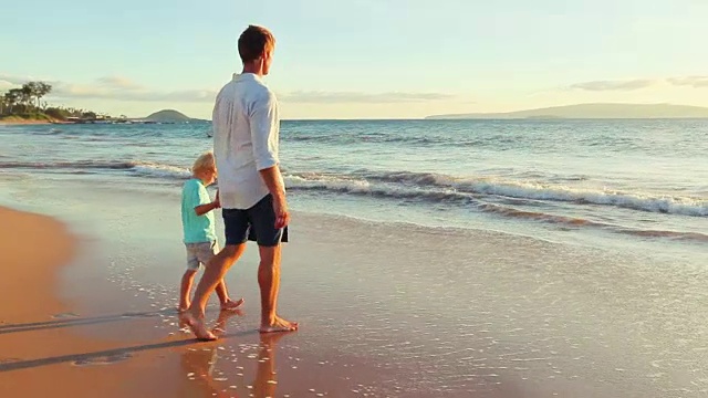 日落时分，父子在海滩上亲密无间。视频素材