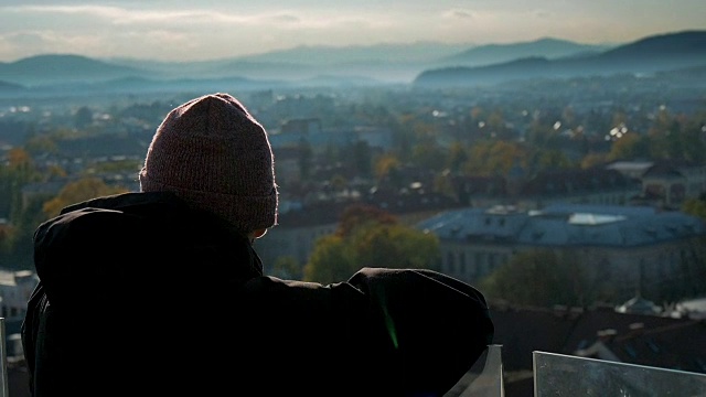 一个游客在秋天的夕阳下俯瞰一座城市视频素材