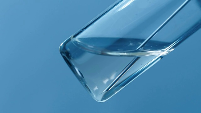 注射器的针头从蓝色背景的玻璃药瓶中取出药物视频素材