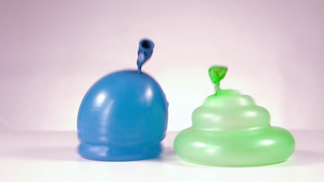 蓝色和绿色的水球落下视频素材