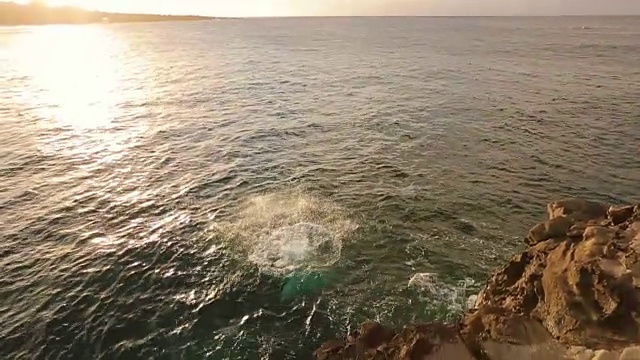 悬崖在日落跳进海洋。视频购买
