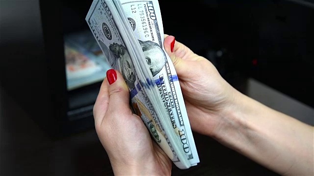女人手里放着美钞视频素材