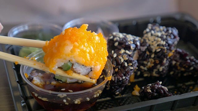 吃蘸酱油的寿司卷视频素材