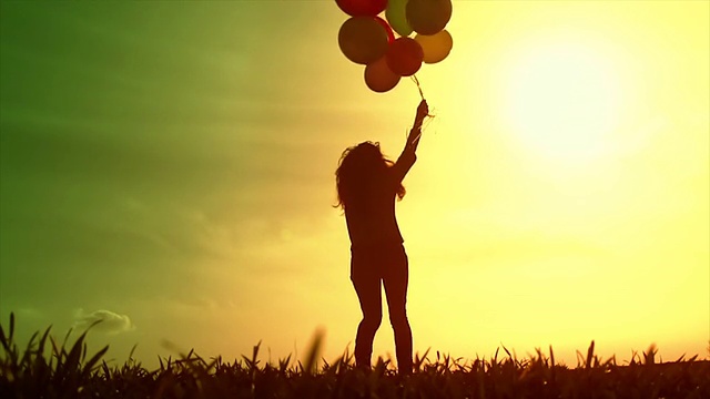 美丽的年轻女子运行草地气球日落快乐视频素材