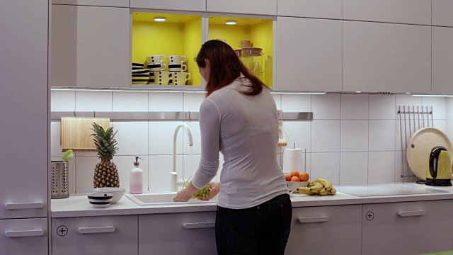 一个女人在厨房的水槽里洗葡萄视频下载