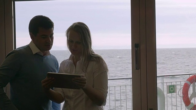 一对年轻夫妇在船上使用平板电脑视频素材