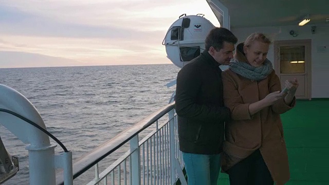 一对年轻夫妇在船上拍手机自拍视频素材