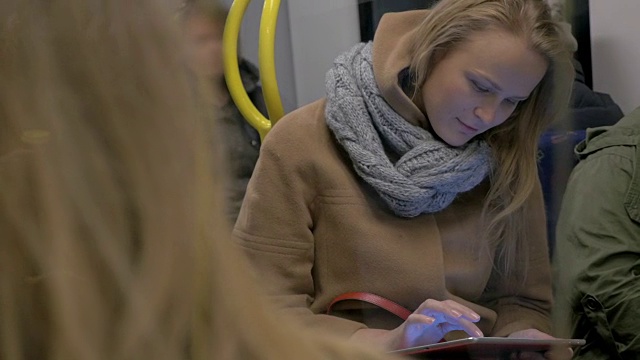 年轻女子在地铁里使用平板电脑视频素材