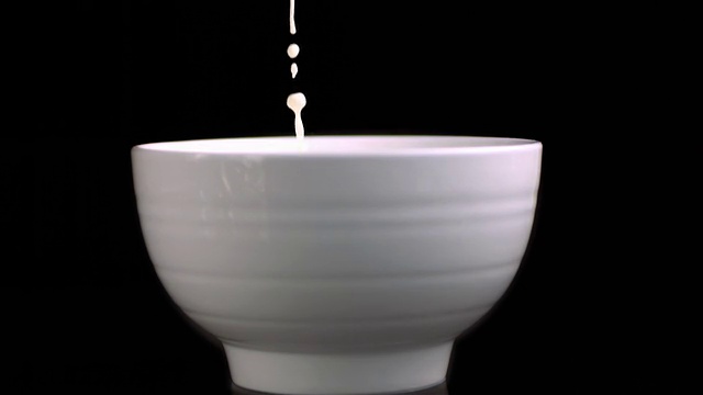 牛奶倒在白色的碗里视频素材
