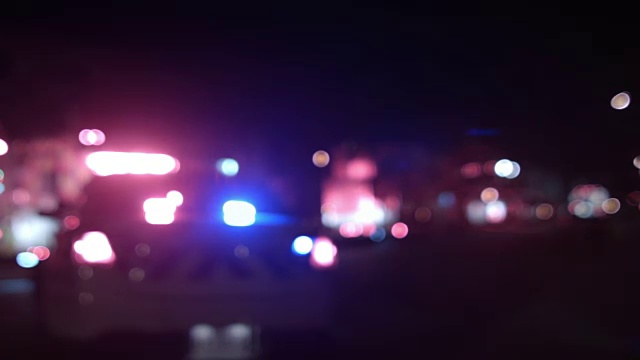 救护车，警察和消防车在夜间模糊灯光平移背景视频下载