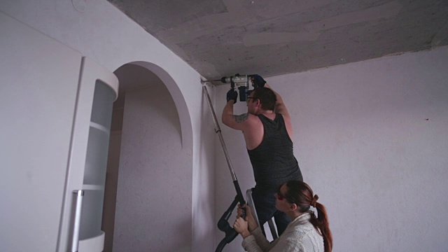 人们用穿孔机在墙上钻了一个洞视频素材