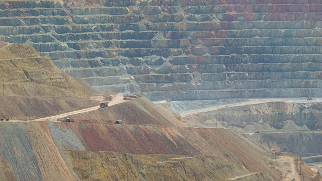 采矿卡车在巨大的铜矿中行驶——长焦镜头拍摄视频下载