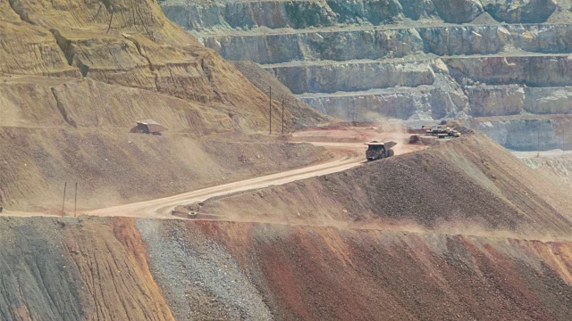 翻车车在巨大的露天铜矿的长焦镜头视频下载