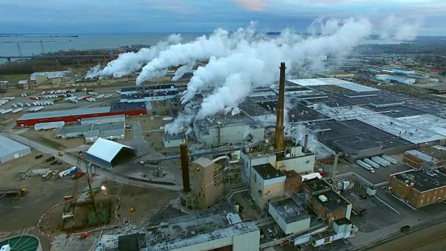 日出时，美丽的工厂烟囱冒出缕缕烟雾，鸟瞰图视频素材