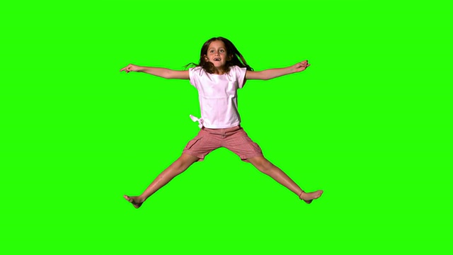 女孩在绿色屏幕上跳上跳下视频素材