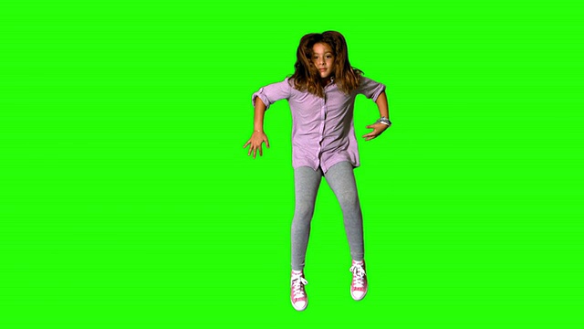 快乐的小女孩在绿色的屏幕上跳跃视频素材