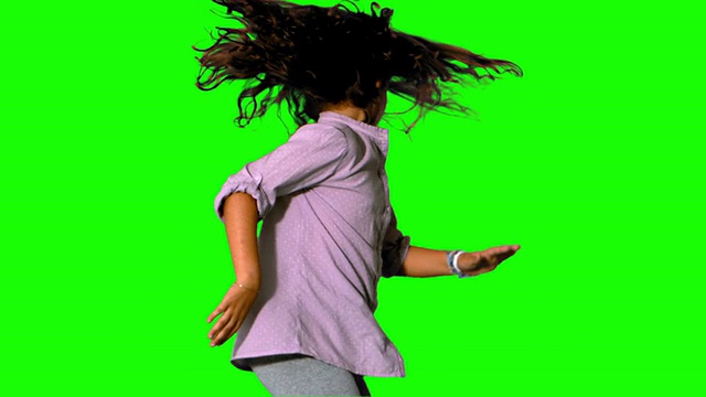 女孩在绿色屏幕上跳来跳去视频素材