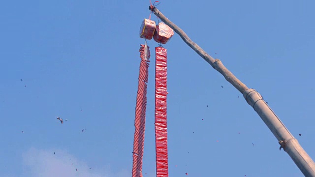 红色的中国鞭炮挂在树枝上庆祝节日的声音。视频素材