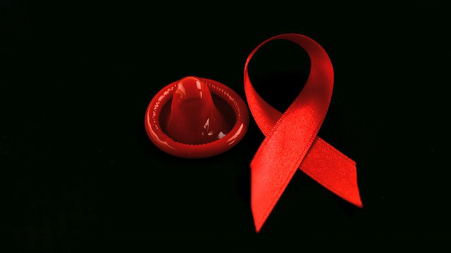 艾滋病红丝带标志落在避孕套旁边视频下载