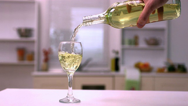 用手将白葡萄酒倒入玻璃杯视频素材