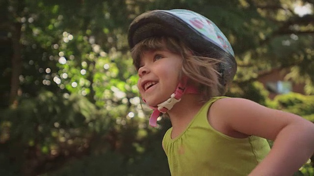 一个可爱的小女孩快乐地骑着她的三轮车视频下载