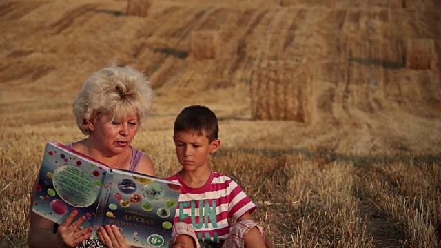 妈妈给儿子读书，在田里，女人给男孩读书视频下载