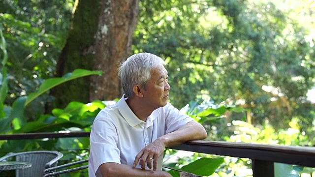亚洲高级家伙在绿色葱郁的自然背景下思考和担心视频素材