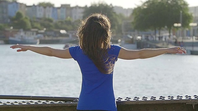在河边，女人对着太阳张开双臂视频下载