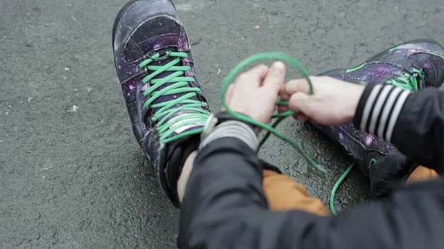 男人系鞋带在特殊的滑雪板靴。特写镜头视频素材
