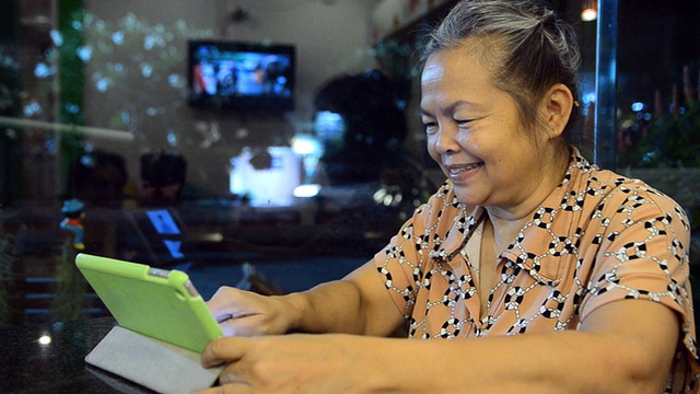 快乐的资深亚洲妇女与平板电脑的肖像视频素材
