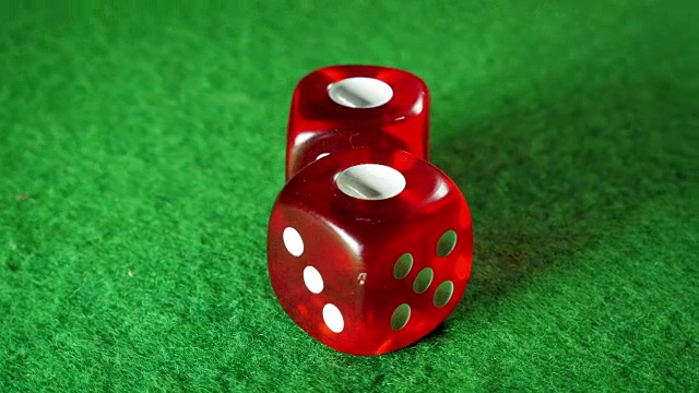 绿布背景上的红色骰子。旋转。一个的两倍。视频素材