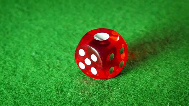 绿布背景上的红色骰子。旋转。1号。视频素材