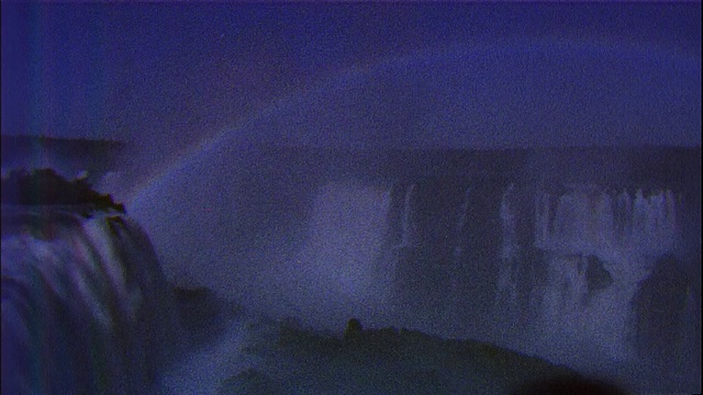 在巴西和阿根廷交界的伊瓜苏瀑布的彩虹上方，潘在夜晚视频素材