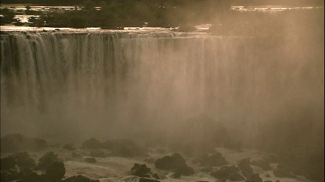 日落时分，巴西和阿根廷边境的伊瓜苏瀑布上雾气弥漫视频素材
