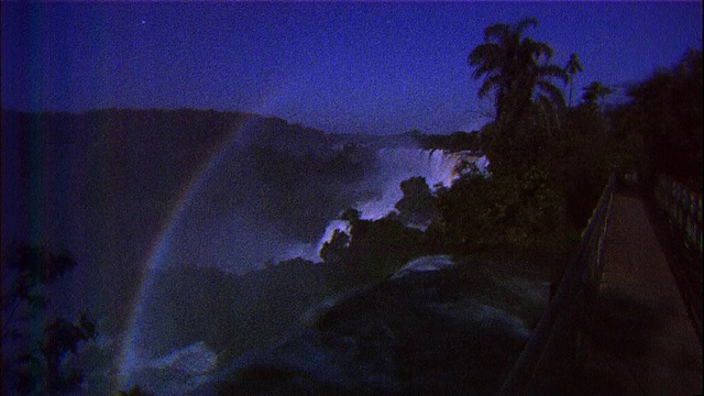在巴西和阿根廷边境的伊瓜苏瀑布上，夜间的雾中出现了彩虹视频素材