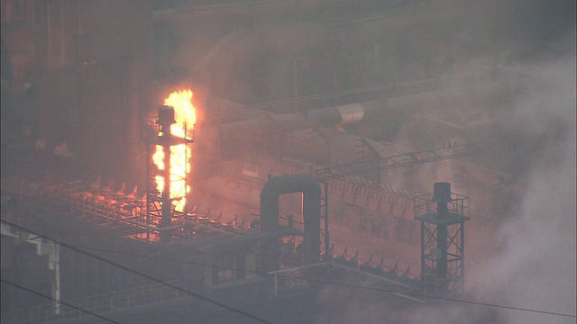 中等镜头的火焰和烟雾在工厂包围在烟雾中视频素材