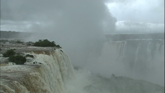 在巴西和阿根廷边界的伊瓜苏瀑布升起的水雾上倾斜视频下载