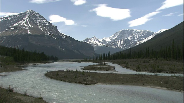 春季，加拿大落基山脉公园的山脉、低松林和高山河流上散落着积雪视频素材
