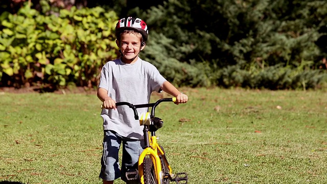 骄傲的孩子骑着自行车走路视频素材