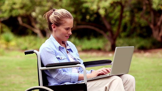 坐在轮椅上用笔记本电脑的美女视频素材