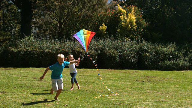 小女孩追着弟弟玩风筝视频素材
