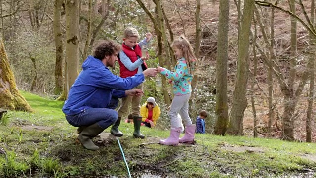成人及儿童在活动中心探索池塘视频素材