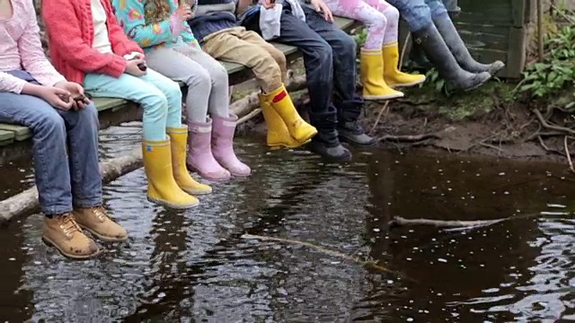 儿童的脚悬挂在木桥上的特写视频素材